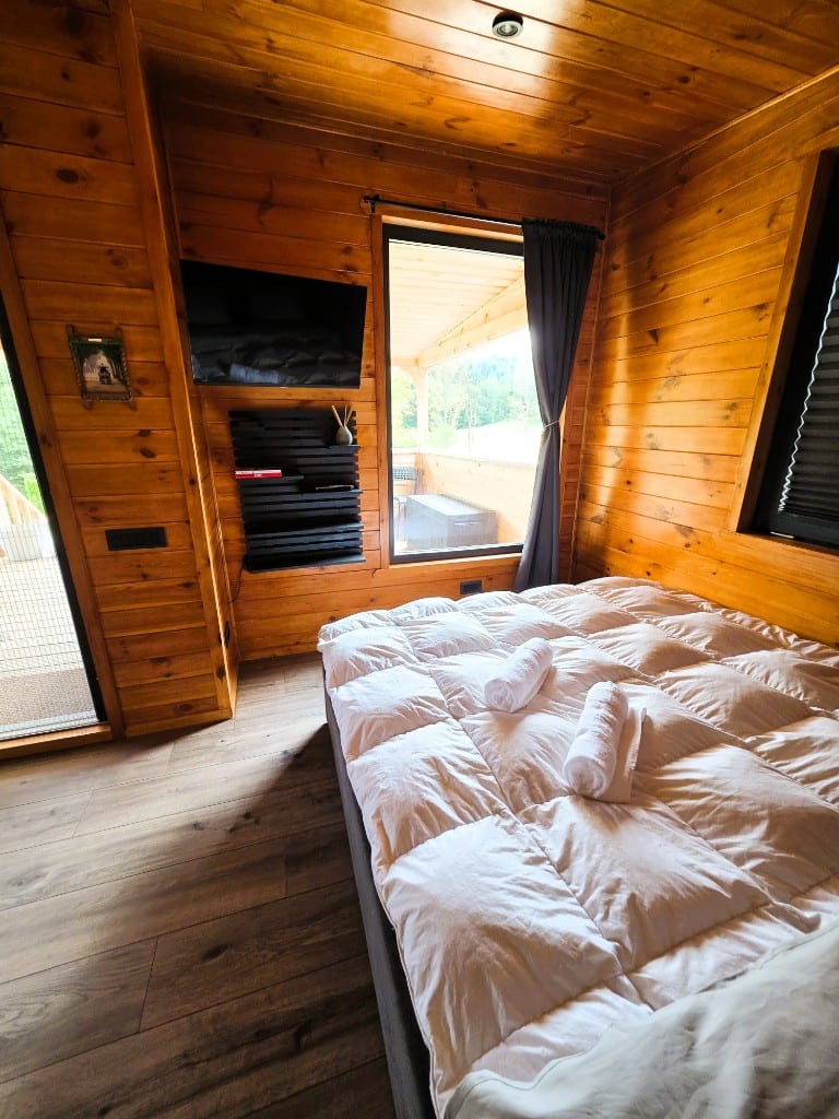 The bed made up with fresh towels, beside the sliding door onto the terrace