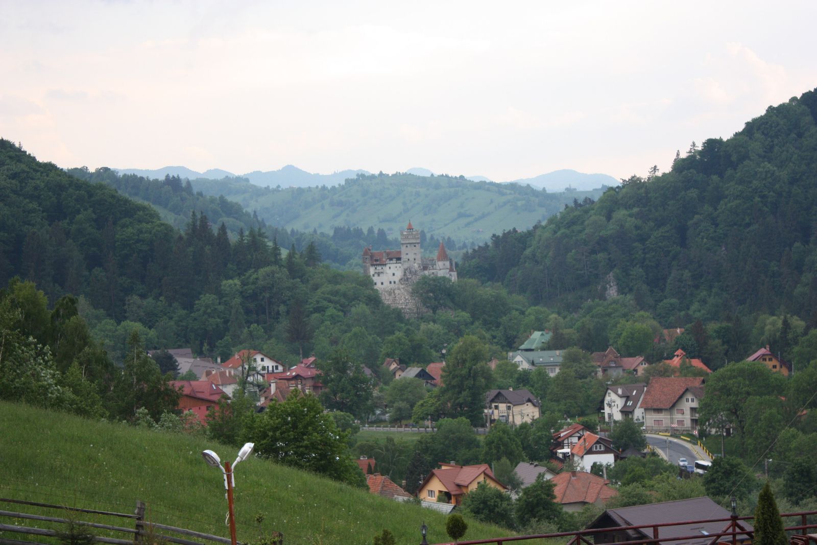 Bran Castle seen from the hillside above the village, with the Carpathian foothills behind
