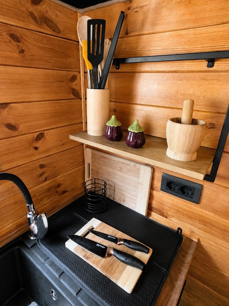 Cooking utensils and a chopping board in the kitchenette