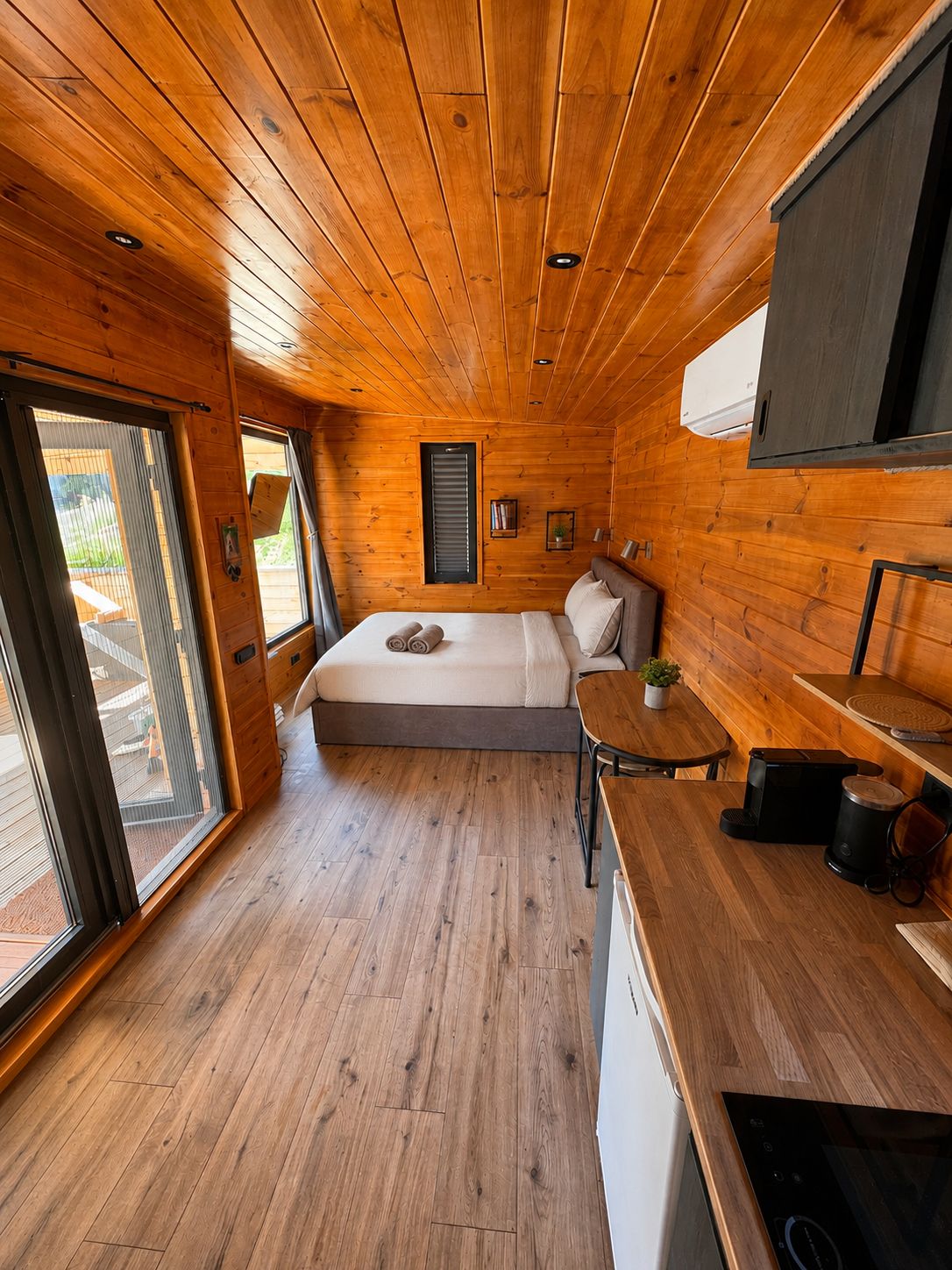 Inside the open-plan cabin: bed, kitchenette and sliding doors onto the terrace